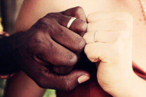 Close up shot of biracial couples hands and wedding rings